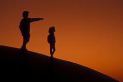 Silhouette of Mother pointing into distance with her daughter